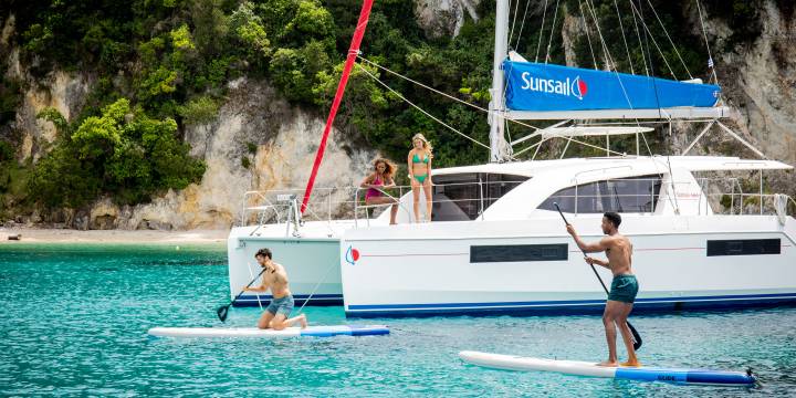 Stand Up Paddling Next To Catamaran At Corfu Island Greece