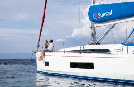 Couple sitting on monohull in Corfu Greece